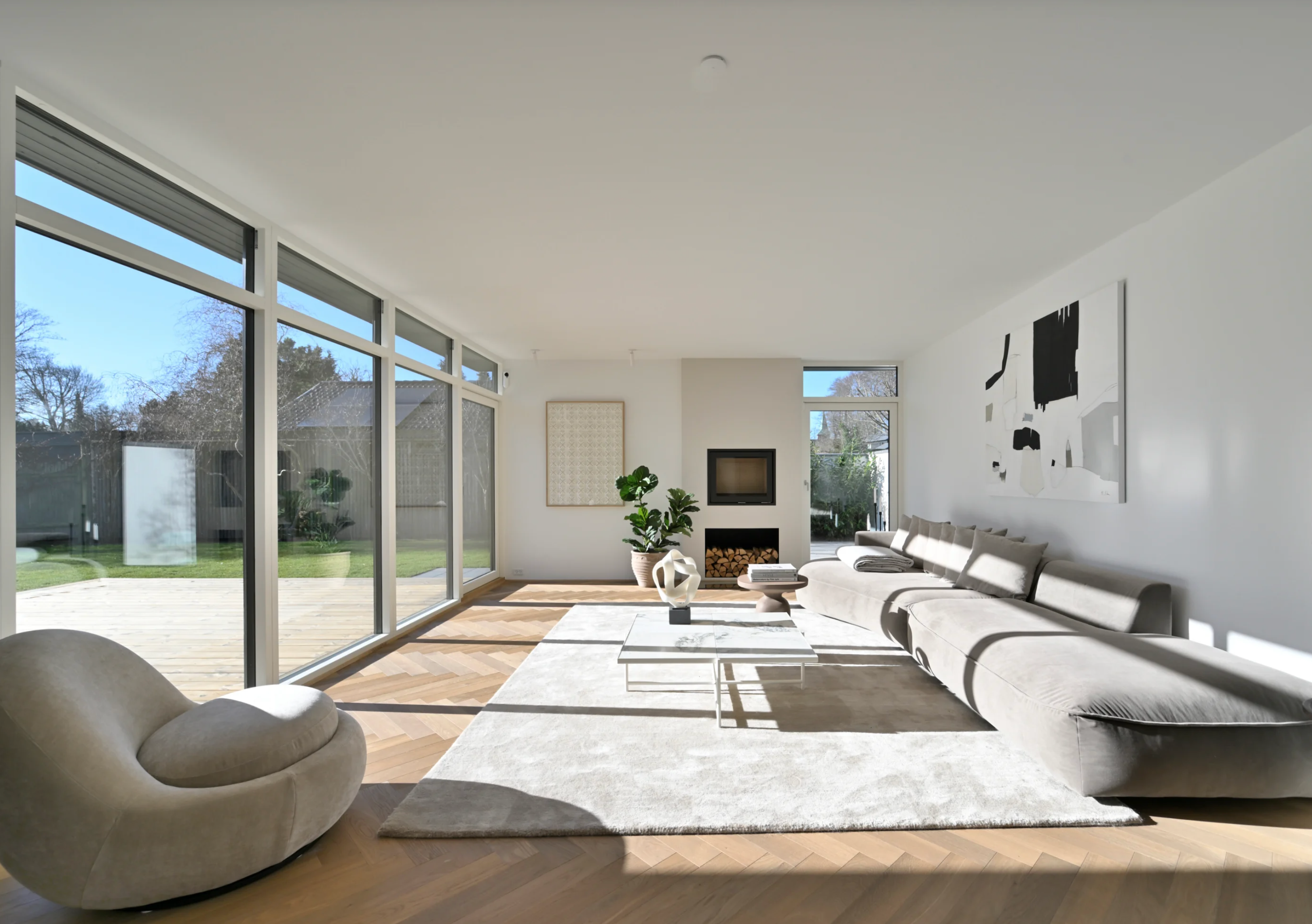 Stue med gulv til loft vinduer hvidt tæpe, organisk sofa – boligstyling af Vosper