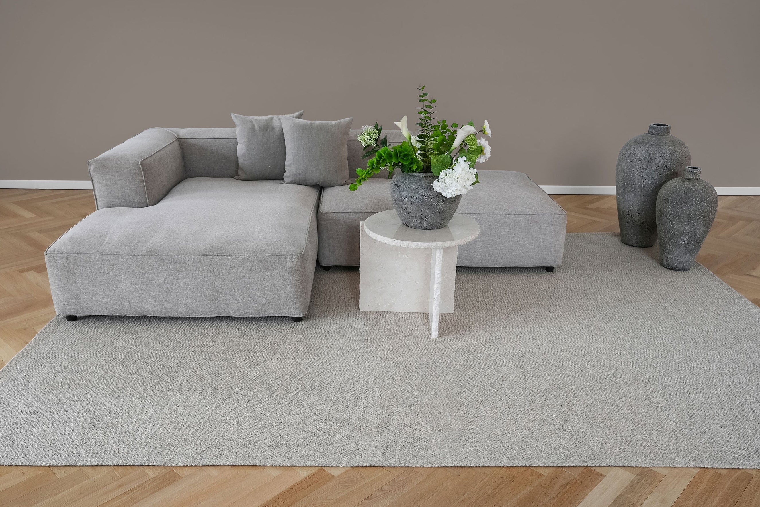 Fladvævet uldtæppe 250x350 cm i lys beige under sofa og bord – stort jacquard tæppe fra Vosper