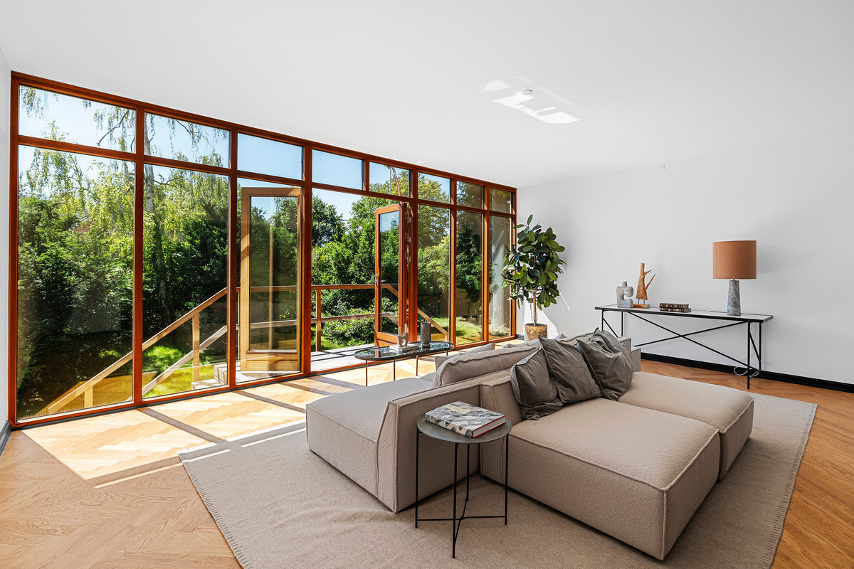Lys stue i eksklusiv villa i Hellerup med modulsofa, varme toner og naturligt lysindfald – stylet af Vosper Boligstyling